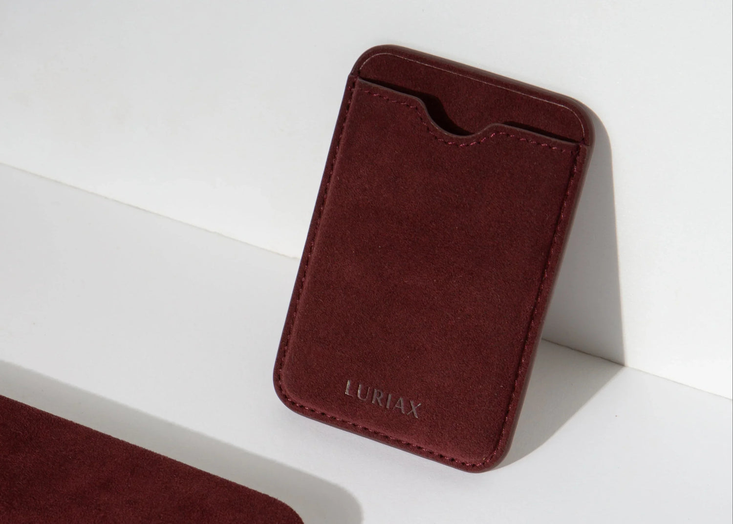 Luriax Bordeaux Alcantara MagSafe wallet angled on white surface