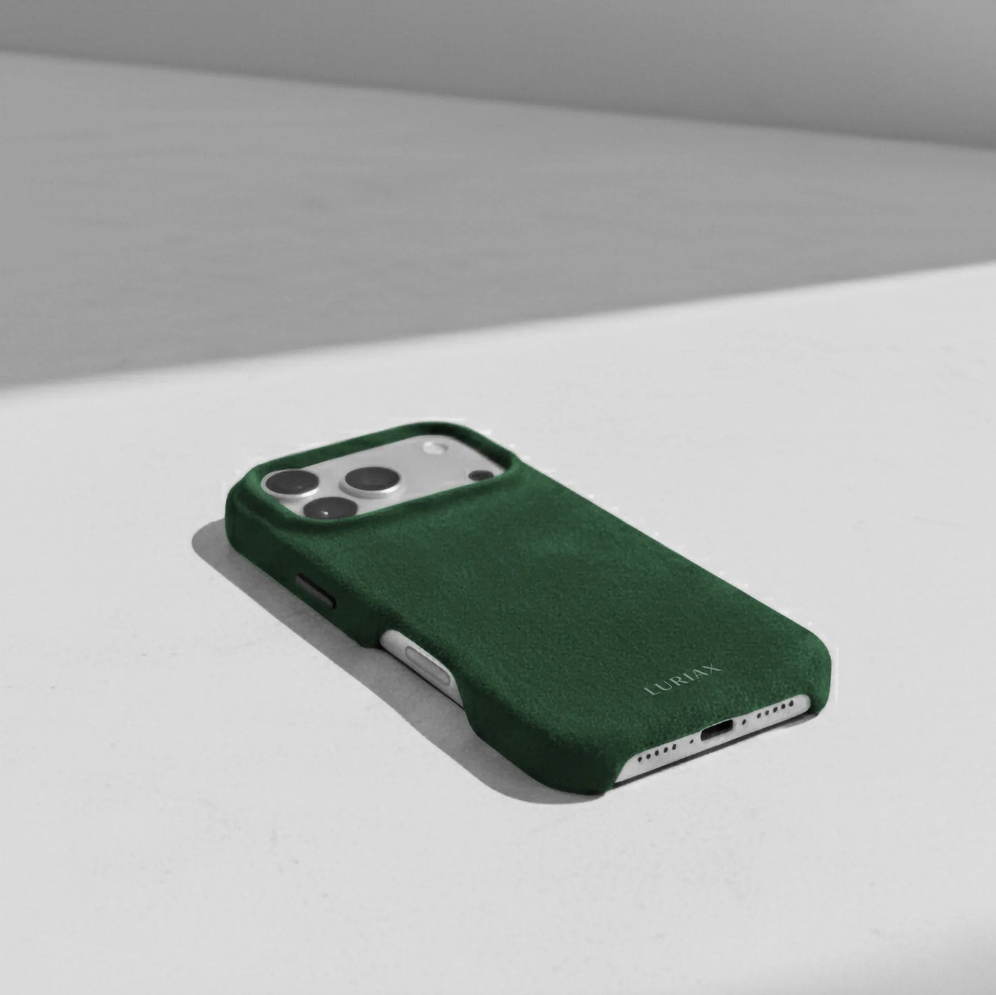 Luriax Signature Alcantara Suede iPhone 17 Pro Max Case in British Racing Green - Lifestyle on table