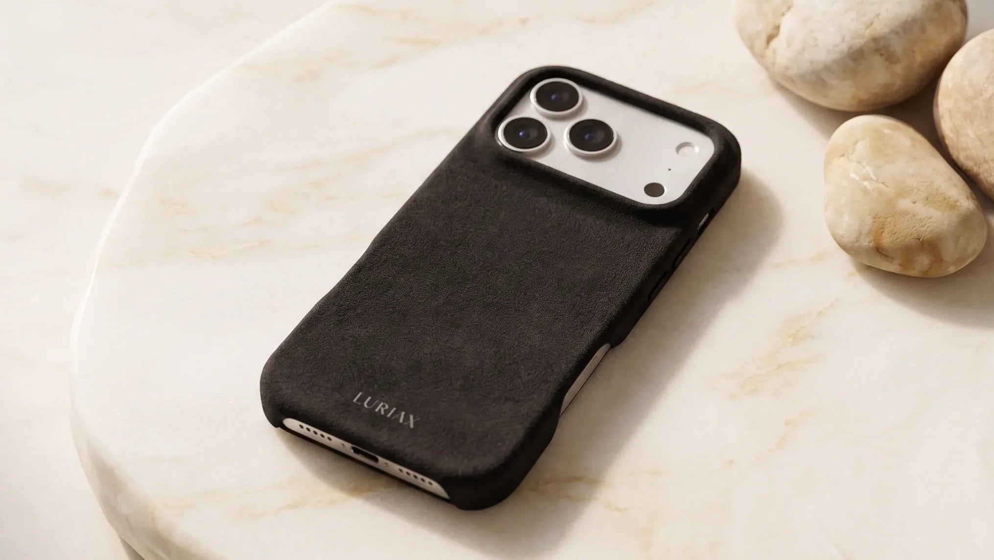 Luriax Black Caviar Alcantara iPhone case with suede texture on marble, MagSafe compatible